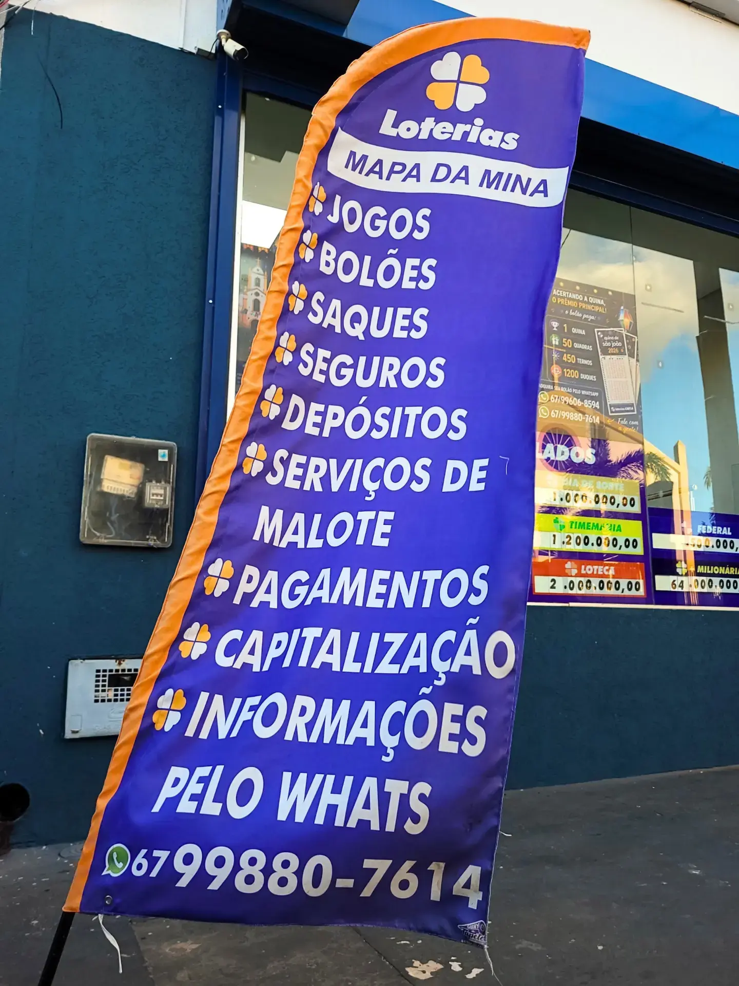 Bandeira com os serviços da lotérica em frente à loja